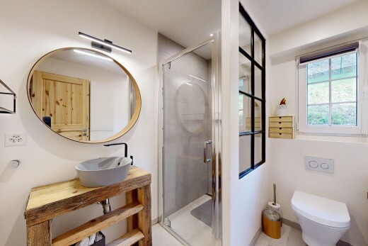 salle de bains avec lumière naturelle, évier, toilette, miroir, et douche