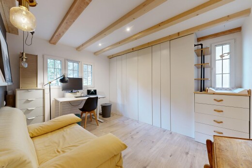 espace intérieur avec sol en finition bois, plafond à poutres, télévision, et lumière naturelle