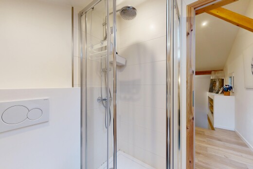 salle de bains avec cloison sèche, douche, salle de bain complète, et sol en finition bois