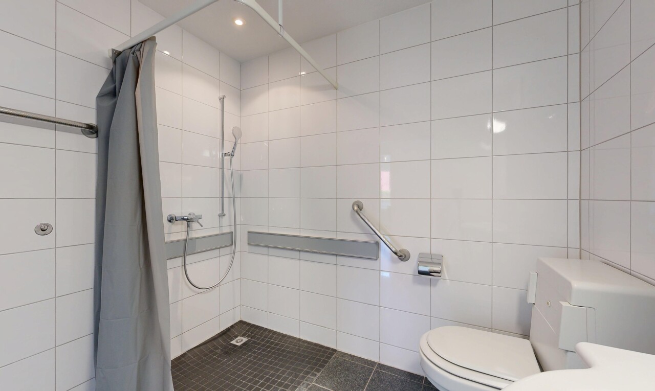 salle de bains avec douche, salle de bain complète, toilette, mur en carrelage, et tile wall