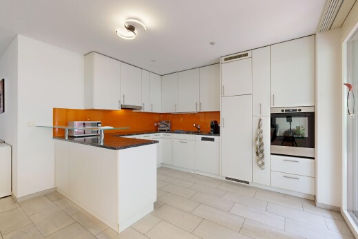 cuisine avec dark countertops, four, light floor, kitchen peninsula, et péninsule de cuisine