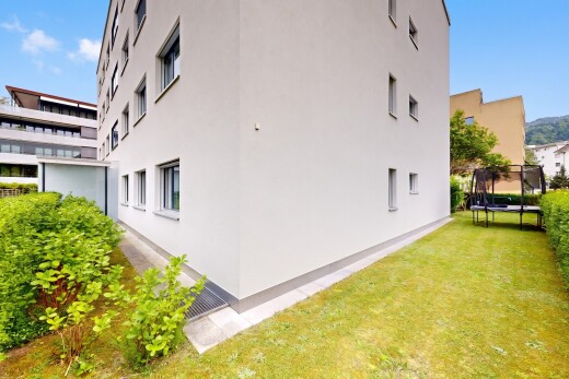 façade avec day time, trampoline, bardage en stuc, pelouse, et apartment complex view