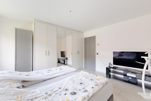 chambre avec drywall, cloison sèche, télévision, light floor, et inside property