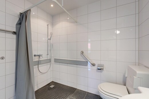 salle de bains avec douche, salle de bain complète, toilette, mur en carrelage, et tile wall
