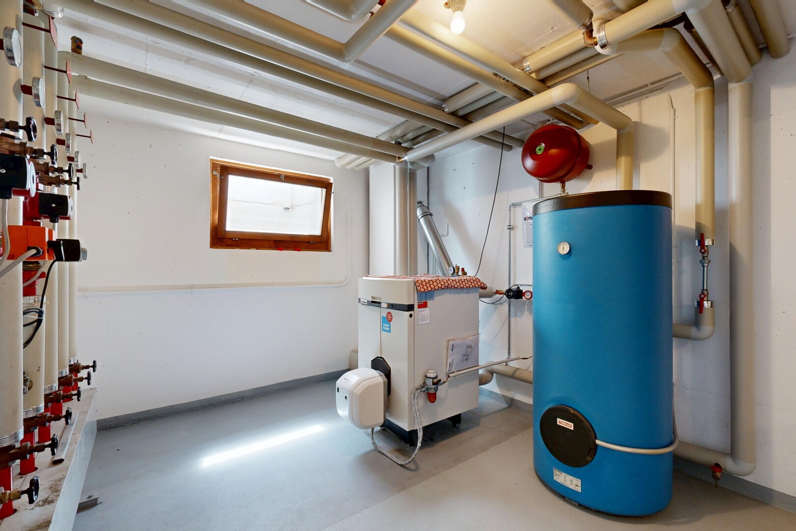 gym avec drywall, cloison sèche, sous-sol, chauffe-eau, et chaudière