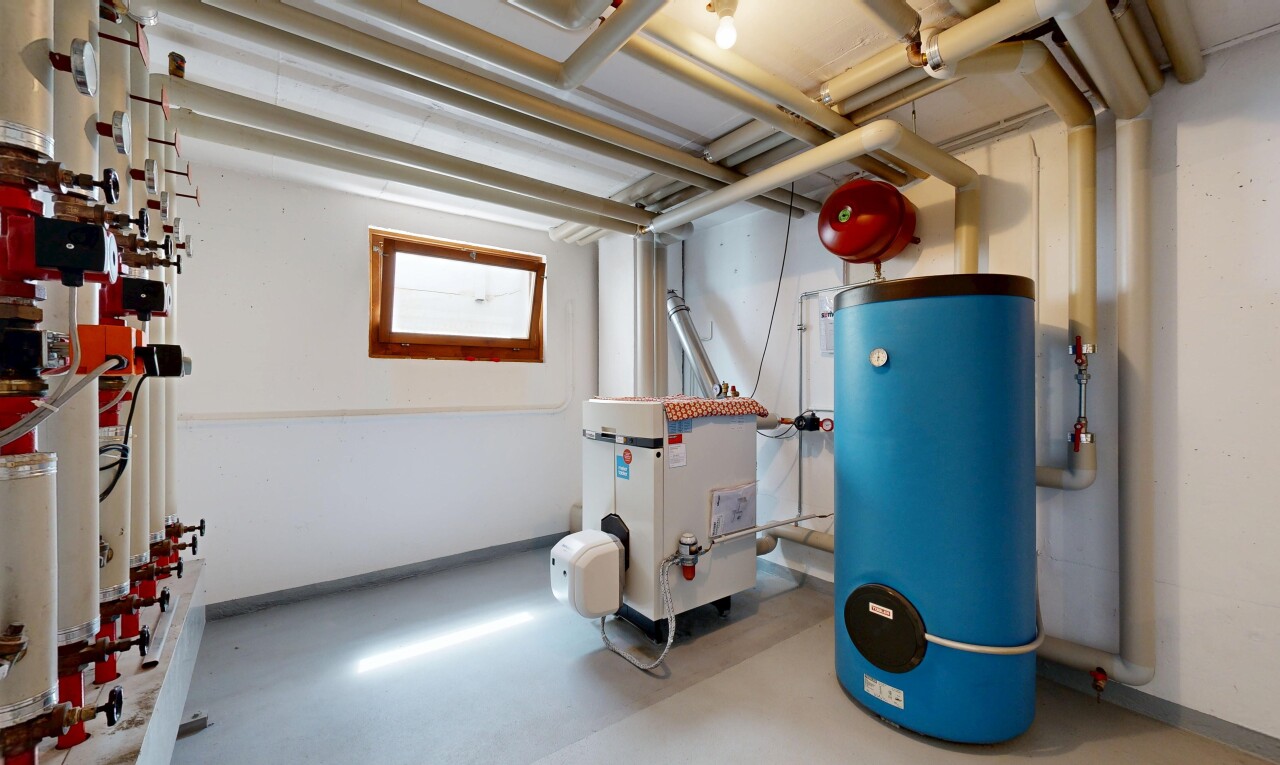 gym avec drywall, cloison sèche, sous-sol, chauffe-eau, et chaudière