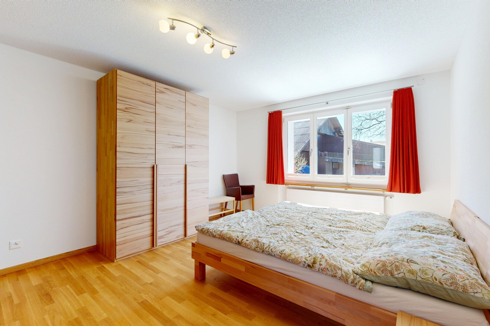 chambre avec cloison sèche, drywall, sol en finition bois, wood finish floor, et lumière naturelle