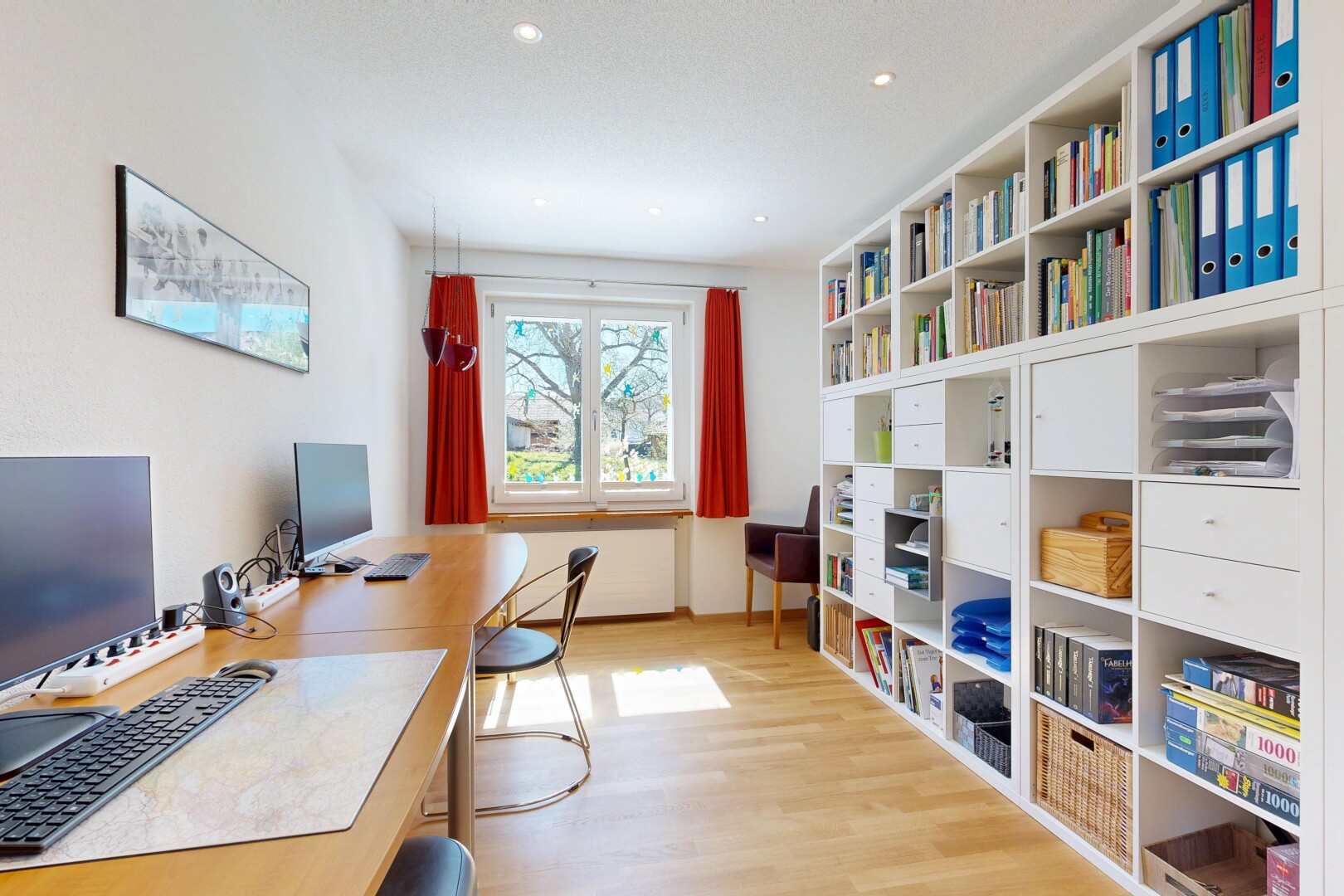 bureau avec télévision, sol en finition bois, wood finish floor, inside property, et light floor