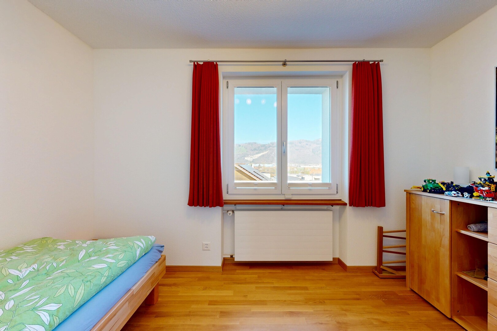 chambre avec radiateur, cloison sèche, drywall, sol en finition bois, et wood finish floor
