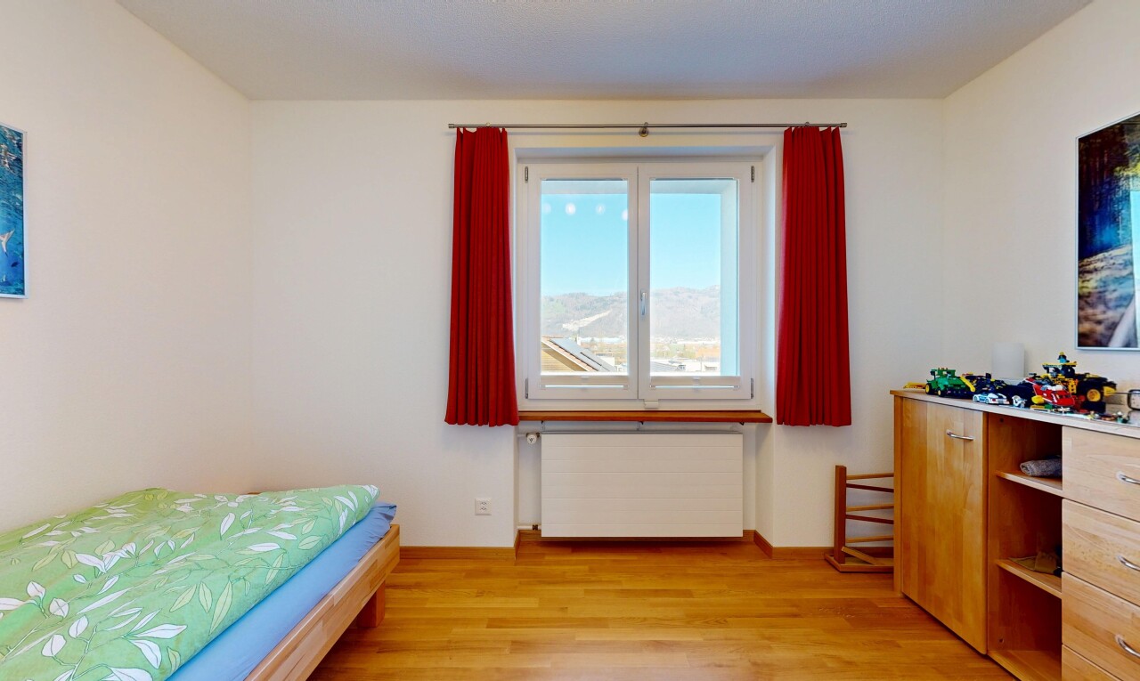 chambre avec radiateur, cloison sèche, drywall, sol en finition bois, et wood finish floor