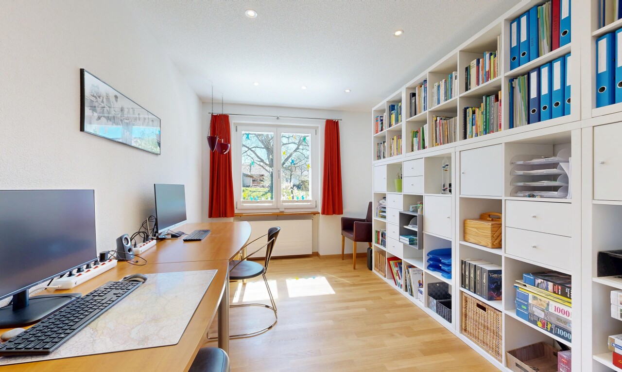 bureau avec télévision, sol en finition bois, wood finish floor, inside property, et light floor