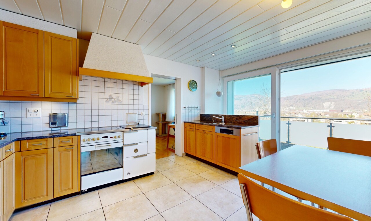 cuisine avec dark countertops, hotte, light floor, medium brown cabinets, et armoires marron moyen