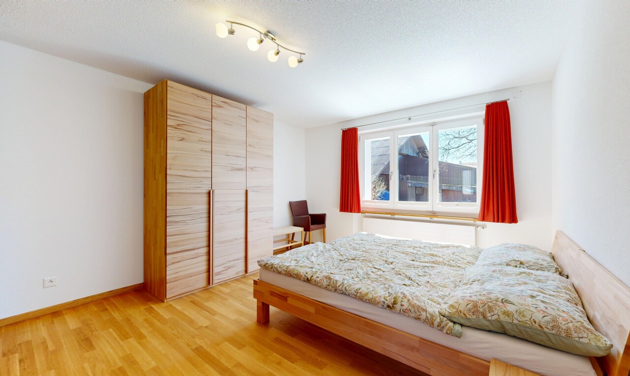 chambre avec cloison sèche, drywall, sol en finition bois, wood finish floor, et lumière naturelle
