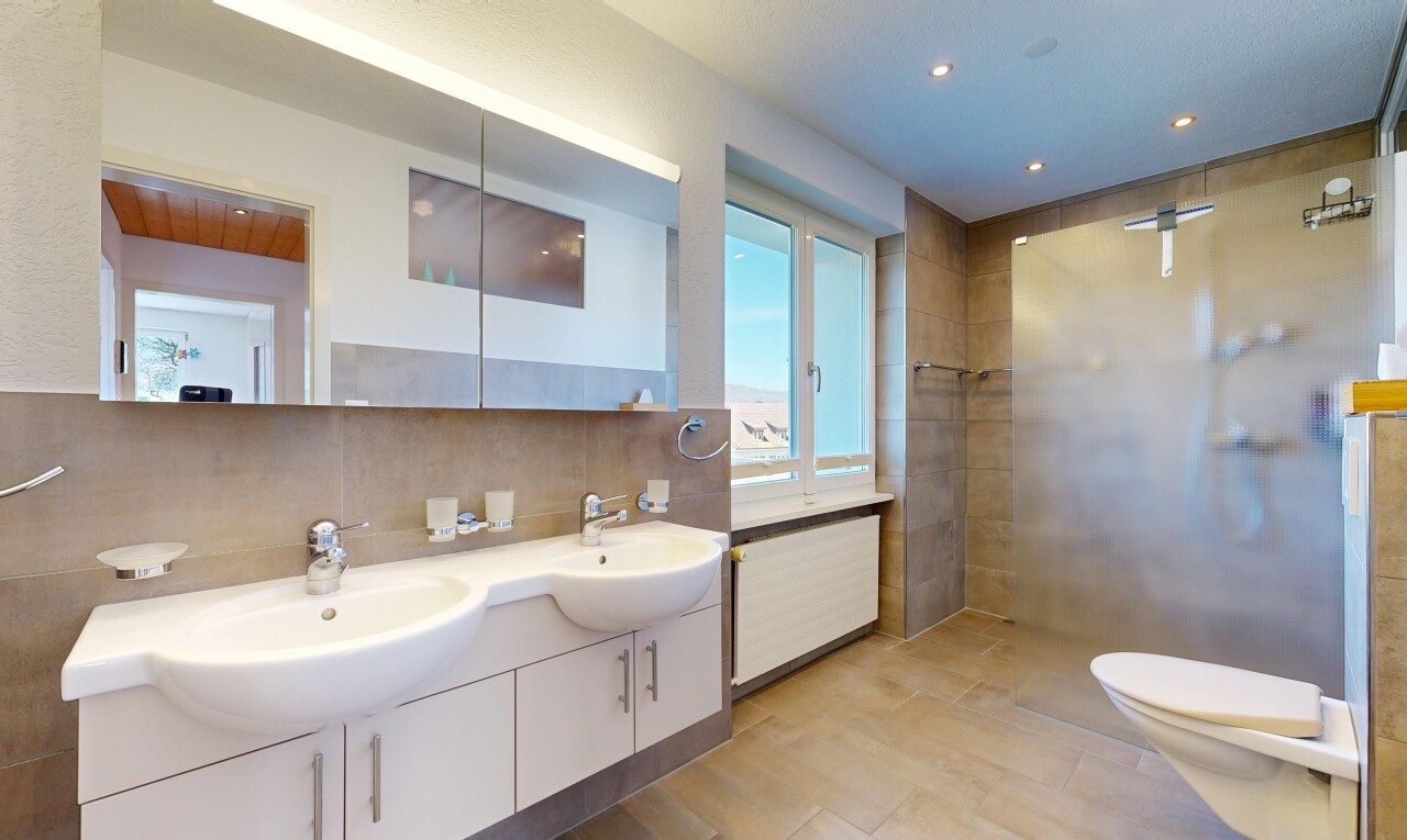 salle de bains avec salle de bain complète, douche, double vasque, light floor, et toilette
