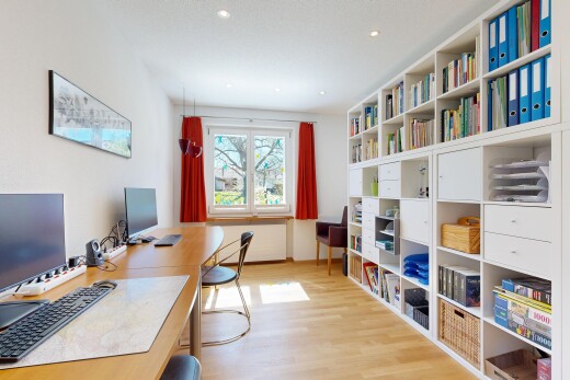 bureau avec télévision, sol en finition bois, wood finish floor, inside property, et light floor