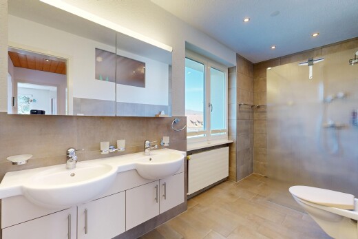 salle de bains avec salle de bain complète, douche, double vasque, light floor, et toilette