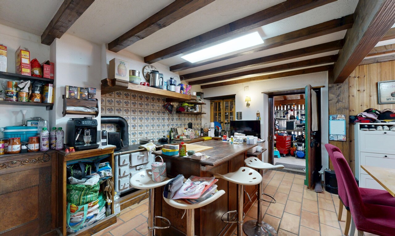 cuisine avec plafond à poutres, beamed ceiling, high end ceiling, télévision, et light floor