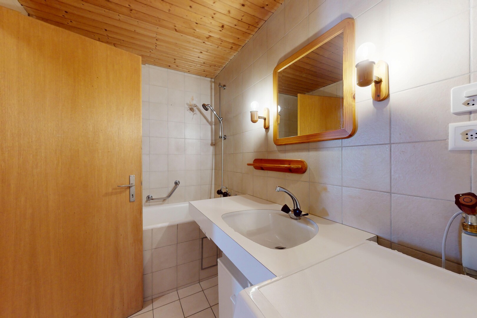 salle de bains avec miroir, salle de bain complète, douche-bain combinés, évier, et mur en carrelage