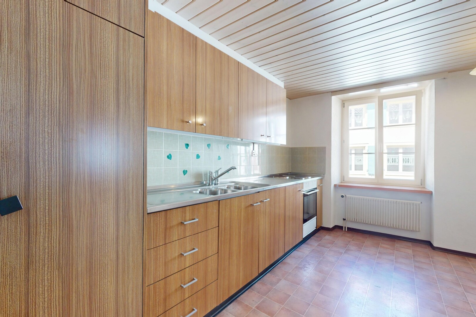 cuisine avec armoires à panneau plat, plans de travail, radiateur, backsplash, et dosseret