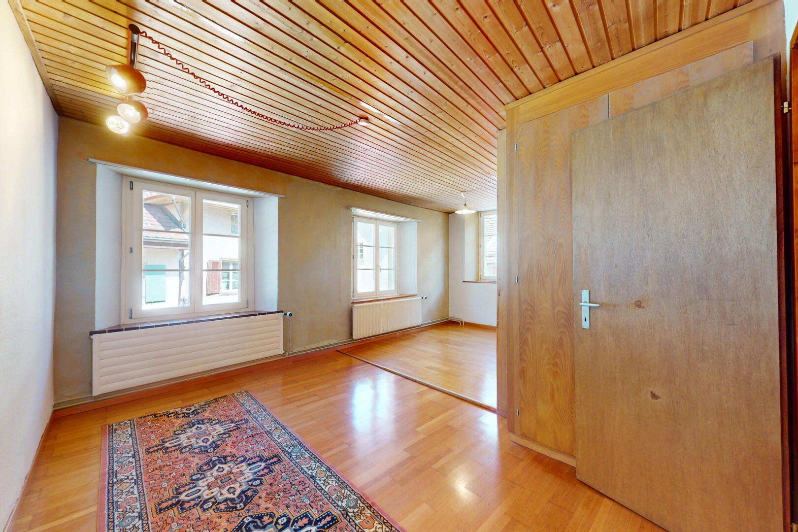 pièce vide avec wood finish floor, sol en finition bois, radiateur, natural light, et lumière naturelle