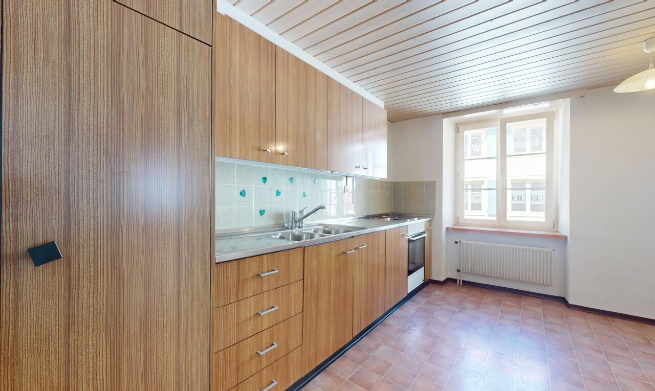 cuisine avec armoires à panneau plat, plans de travail, radiateur, backsplash, et dosseret