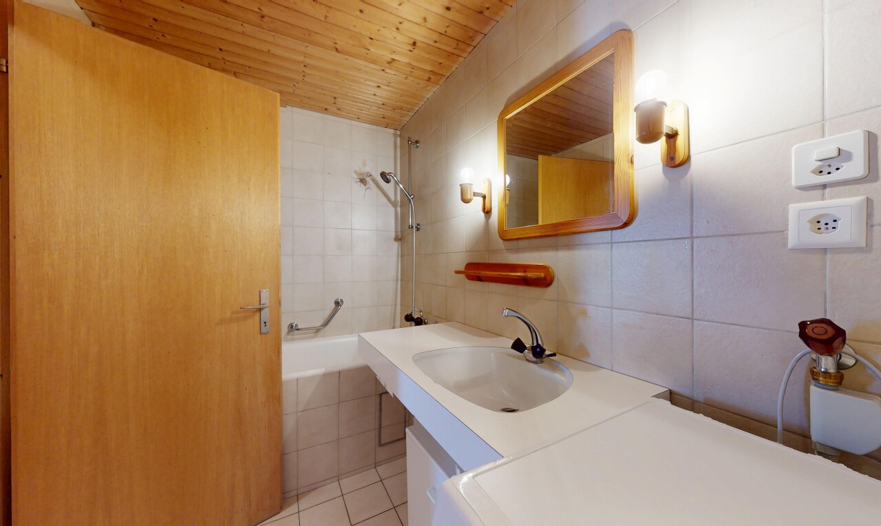 salle de bains avec miroir, salle de bain complète, douche-bain combinés, évier, et mur en carrelage