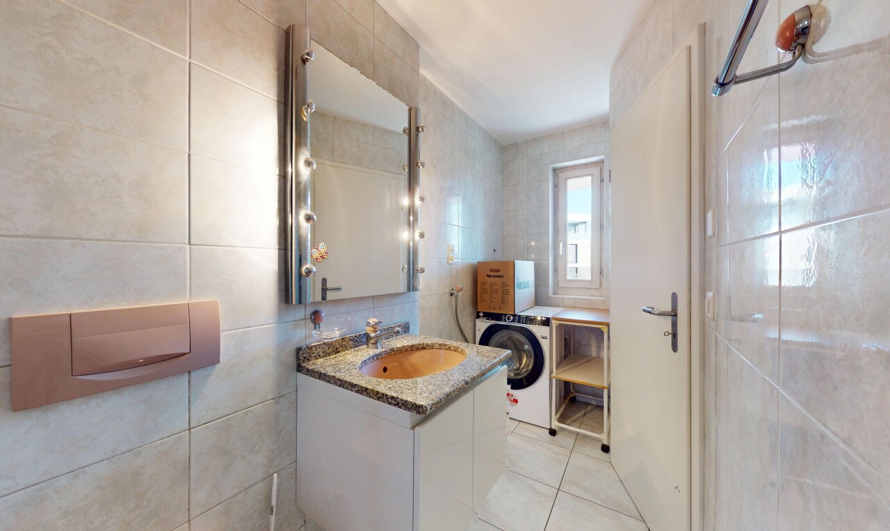 salle de bains avec mur en carrelage, tile wall, miroir, lave-linge et sèche-linge, et lavabo (ou coiffeuse selon le contexte)