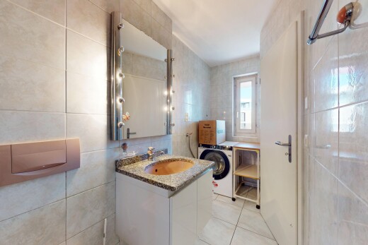 salle de bains avec mur en carrelage, tile wall, miroir, lave-linge et sèche-linge, et lavabo (ou coiffeuse selon le contexte)