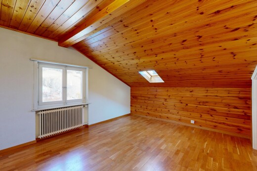 pièce vide avec radiateur, mur en bois, wood wall, plafond voûté, et vaulted ceiling