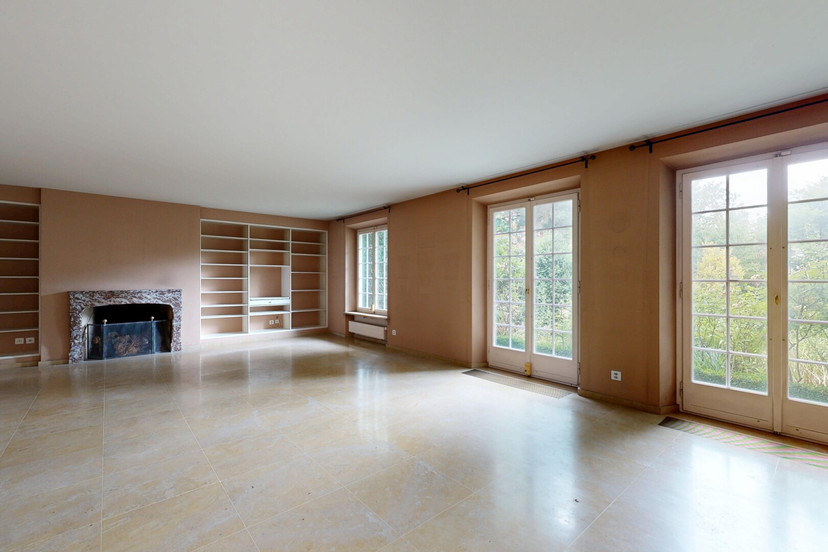 leerer raum mit inside property, eingebaute regale, built in shelves, kamin, und natürliches licht