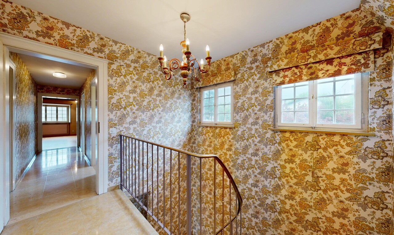 halle / korridor mit natürliches licht, natural light, bemerkenswerter kronleuchter, inside property, und tapetenwand