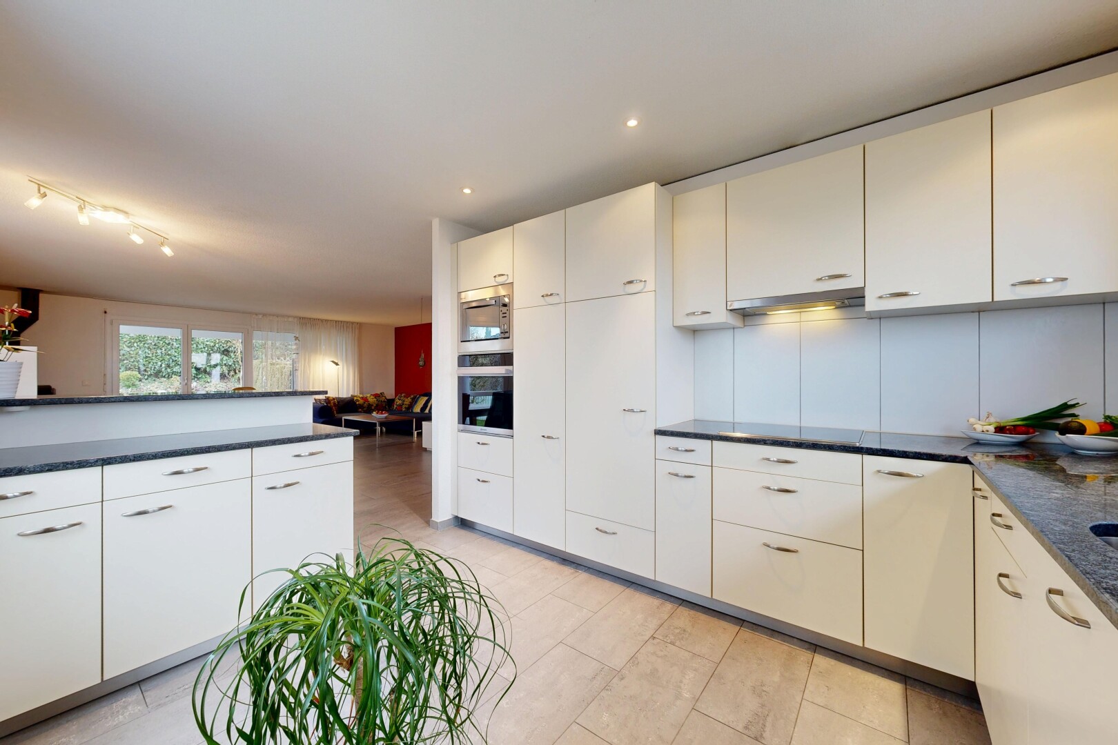 cuisine avec dark countertops, two heights countertops, lumière naturelle, natural light, et light floor