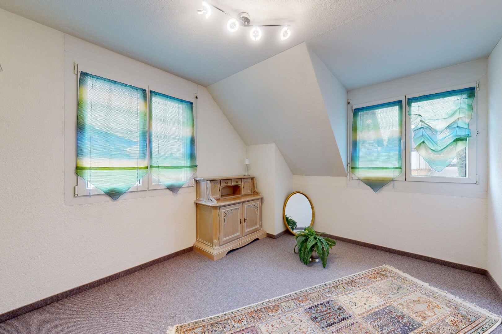 pièce vide avec moquette, carpet, plafond voûté, vaulted ceiling, et lumière naturelle