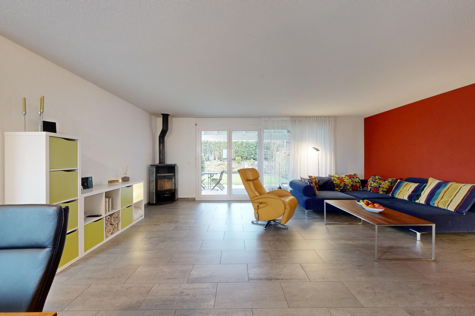 salon avec drywall, cloison sèche, poêle à bois, inside property, et natural light