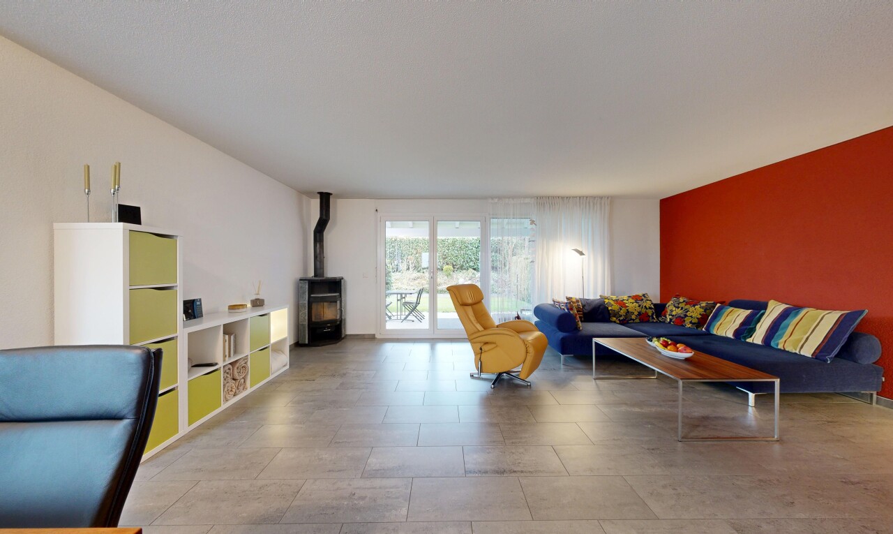 salon avec drywall, cloison sèche, poêle à bois, inside property, et natural light