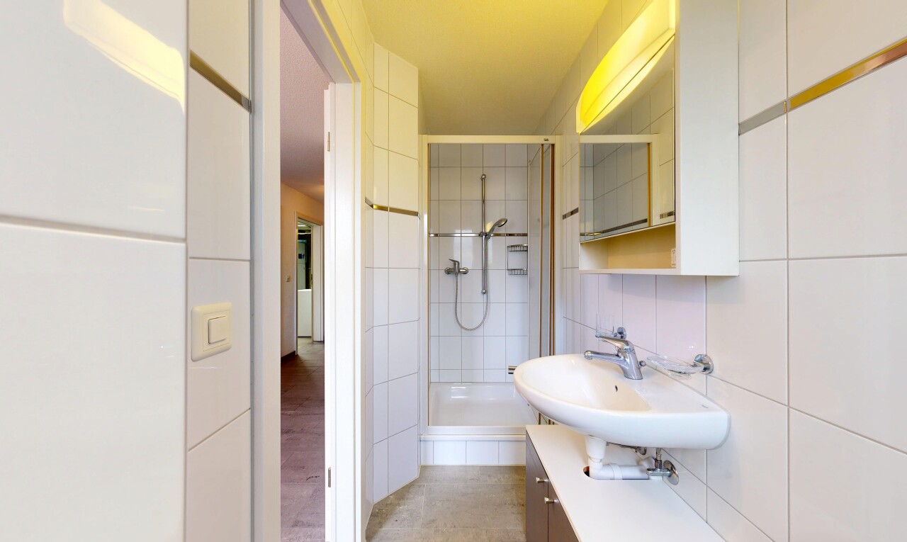 salle de bains avec miroir, douche, salle de bain complète, light floor, et évier
