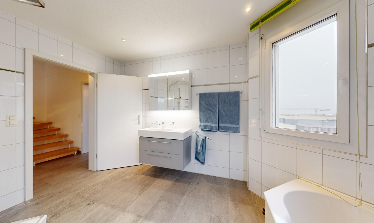salle de bains avec mur en carrelage, tile wall, salle de bain complète, lavabo (ou coiffeuse selon le contexte), et lumière naturelle