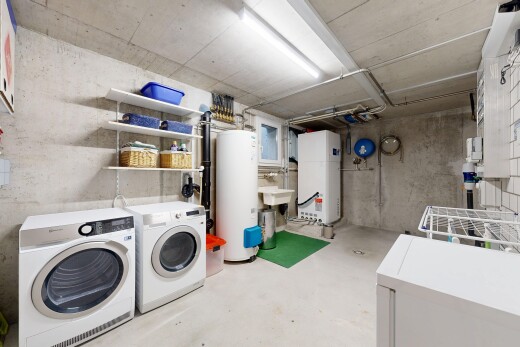 laundry room featuring electric water heater, concrete floors, and independent washer and dryer