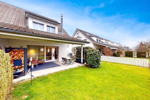 outdoor house with a patio area, a tile roof, stucco siding, and a chimney