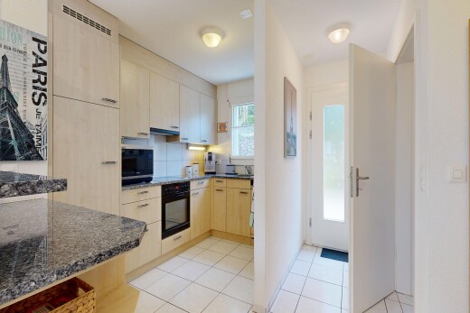 cuisine avec dark countertops, light floor, light brown cabinets, armoires marron clair, et natural light