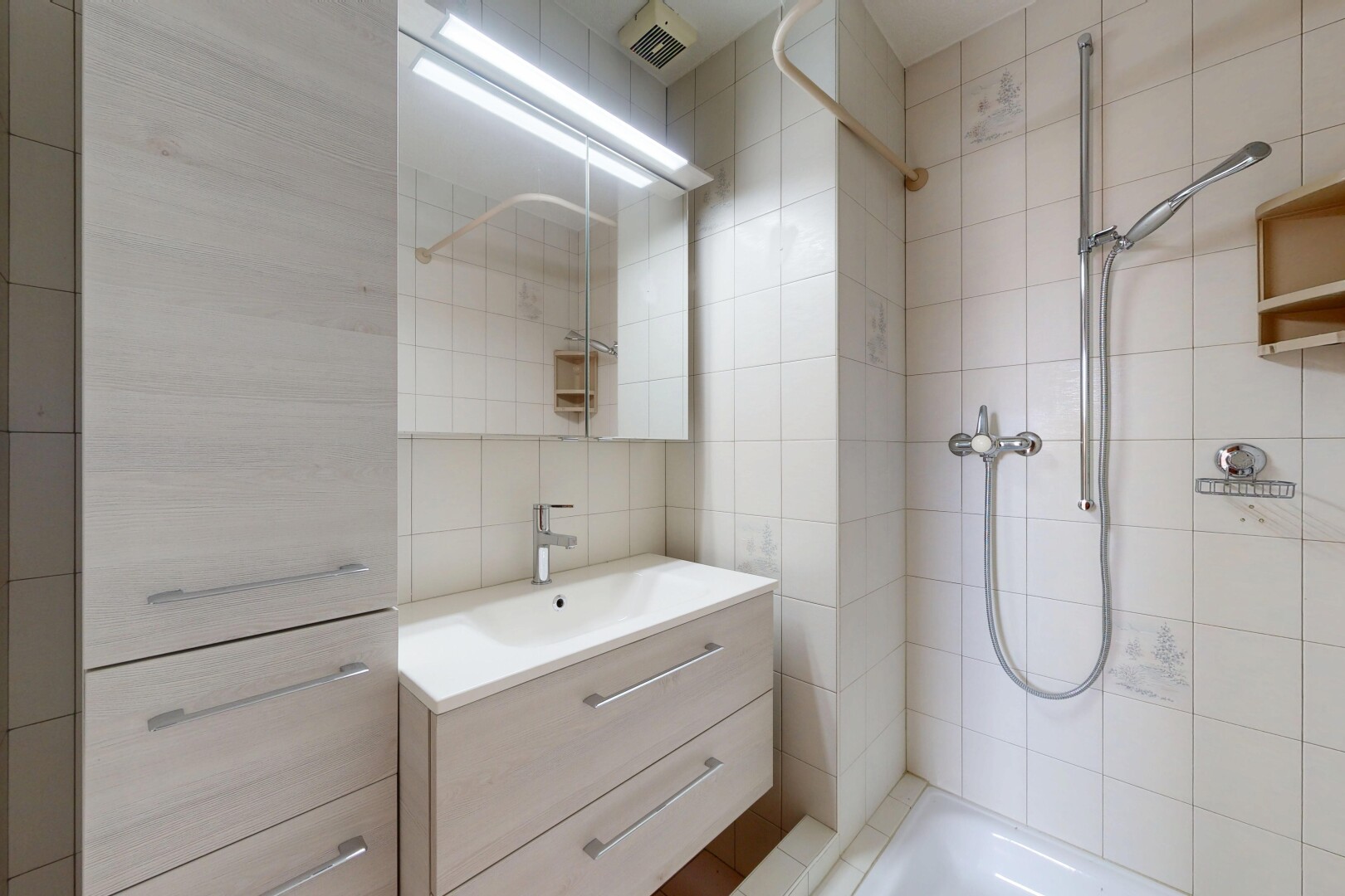 salle de bains avec miroir, lavabo (ou coiffeuse selon le contexte), salle de bain complète, douche, et inside property