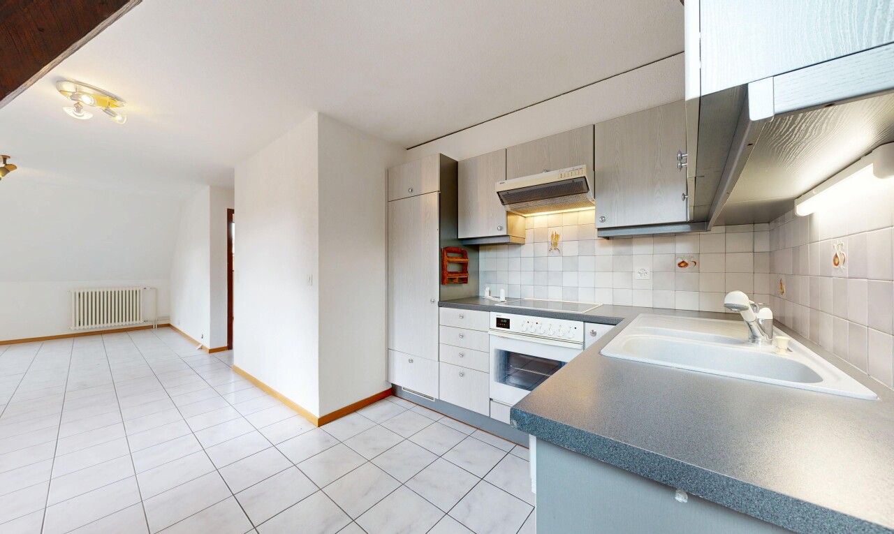 cuisine avec light floor, plans de travail, dark countertops, hotte, et four