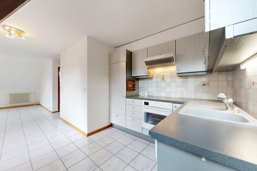 cuisine avec light floor, plans de travail, dark countertops, hotte, et four
