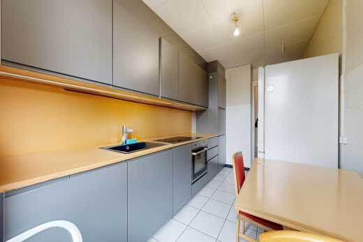 cuisine avec armoires grises, gray cabinets, light floor, réfrigérateur, et armoires à panneau plat