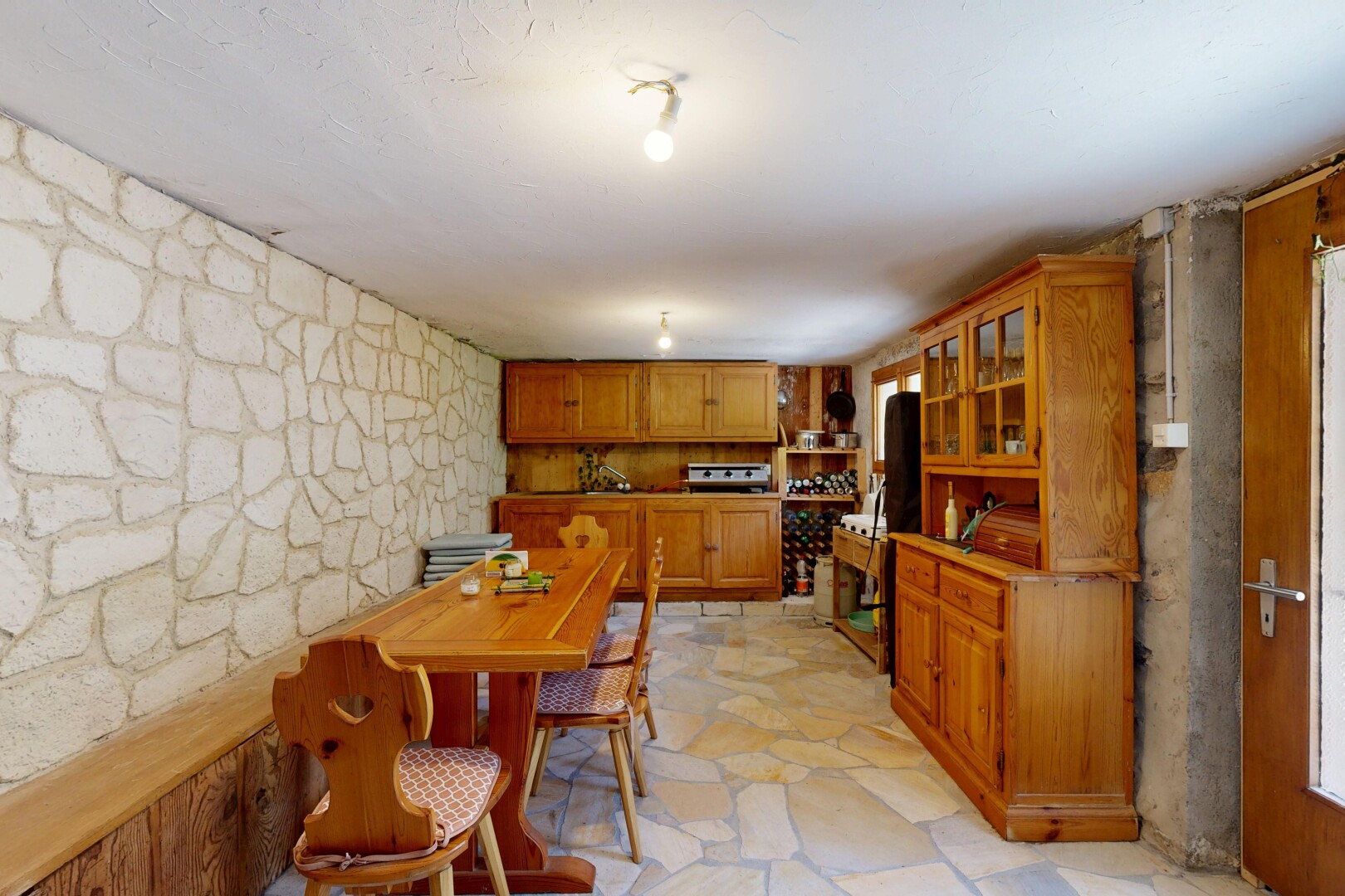 salle à manger avec mur en pierre, stone wall, flagstone, sol en finition pierre, et stone finish floor