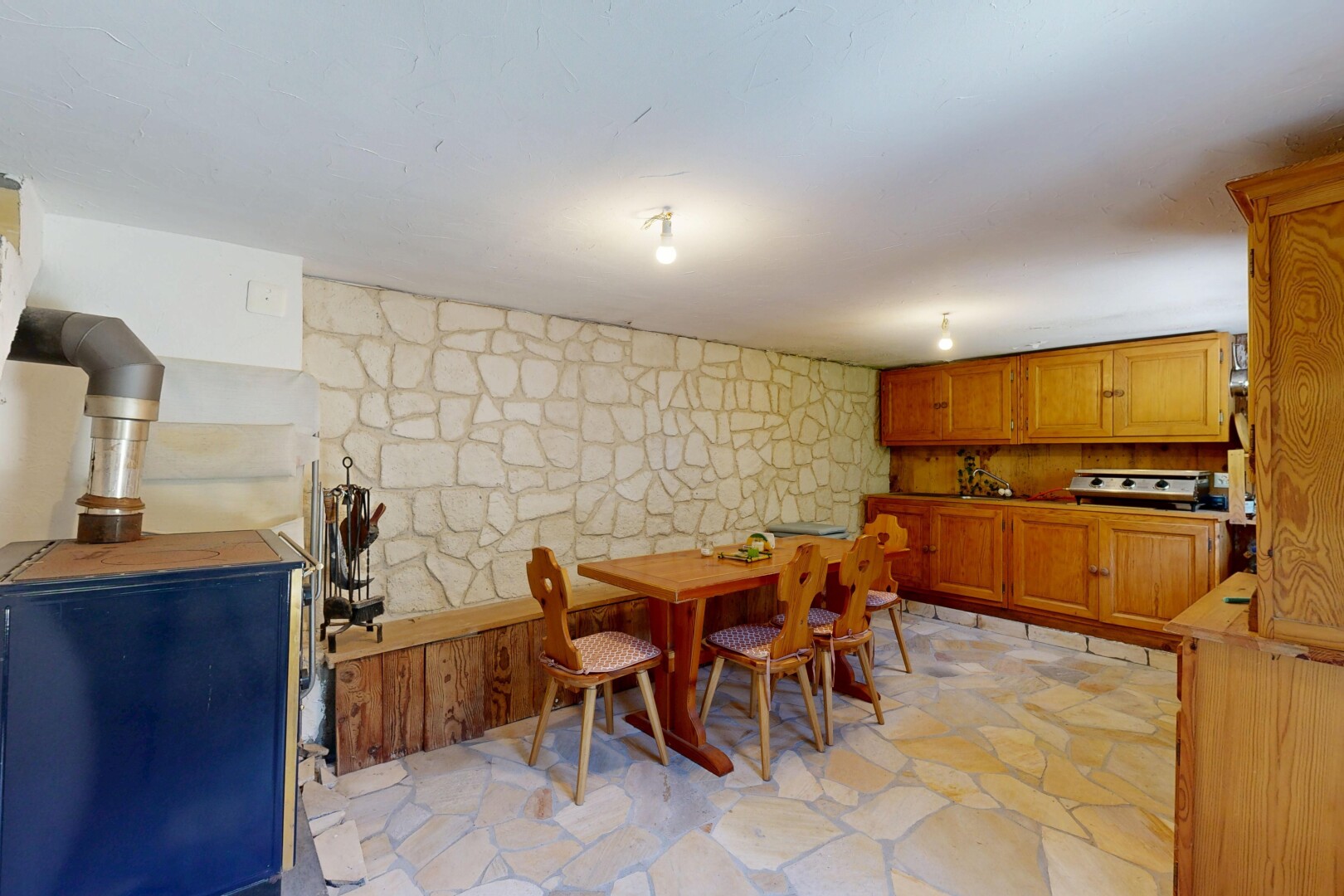 salle à manger avec mur en pierre, stone wall, flagstone, sol en finition pierre, et stone finish floor