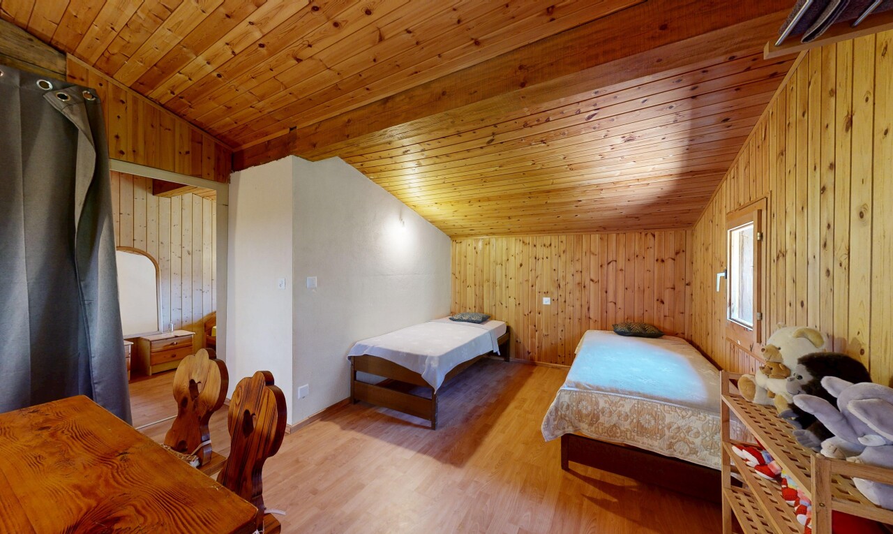 chambre avec wood wall, mur en bois, vaulted ceiling, plafond voûté, et wood finish floor