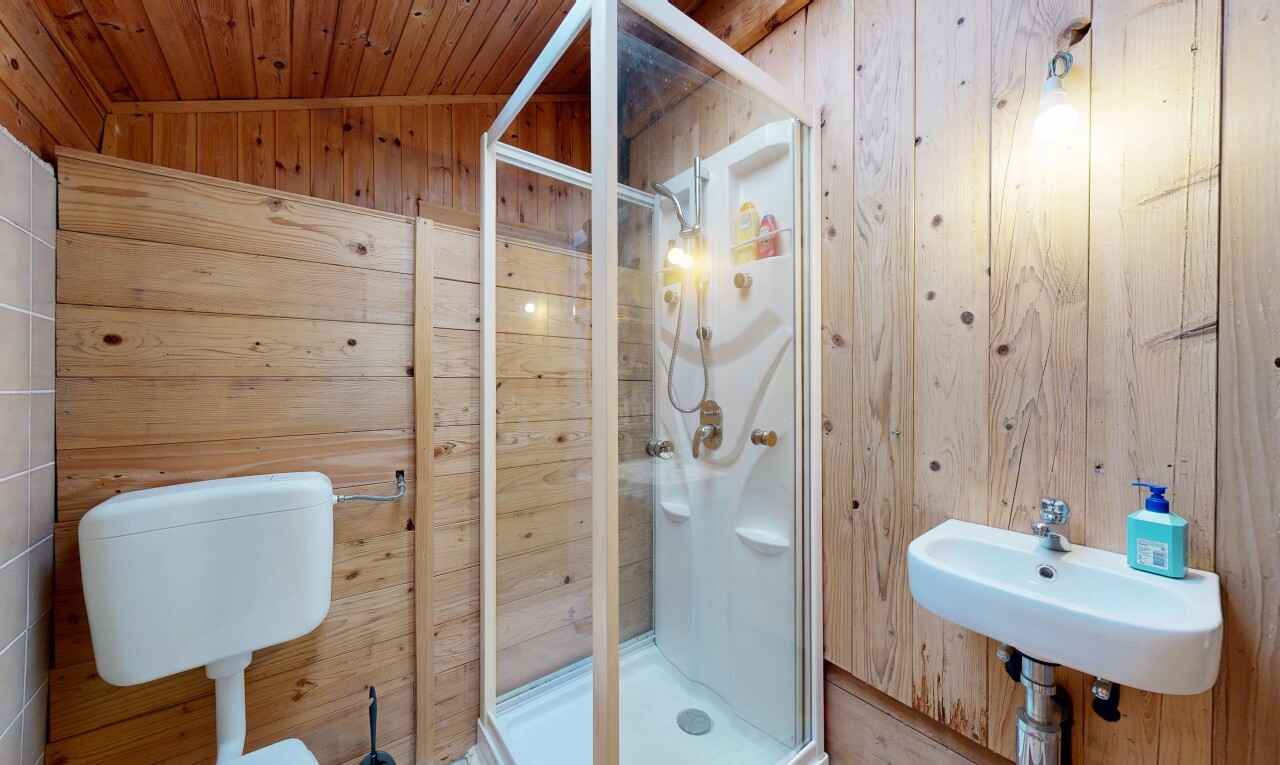 salle de bains avec wood wall, mur en bois, douche, évier, et salle de bain complète