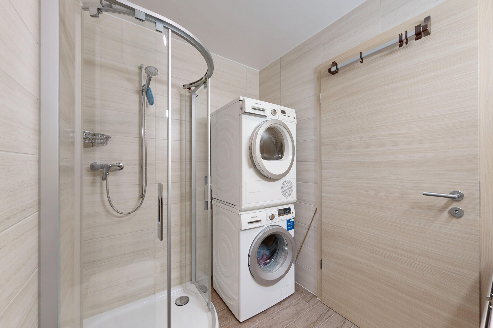 salle de bains avec salle de bain complète, douche, lave-linge et sèche-linge superposés, et inside property