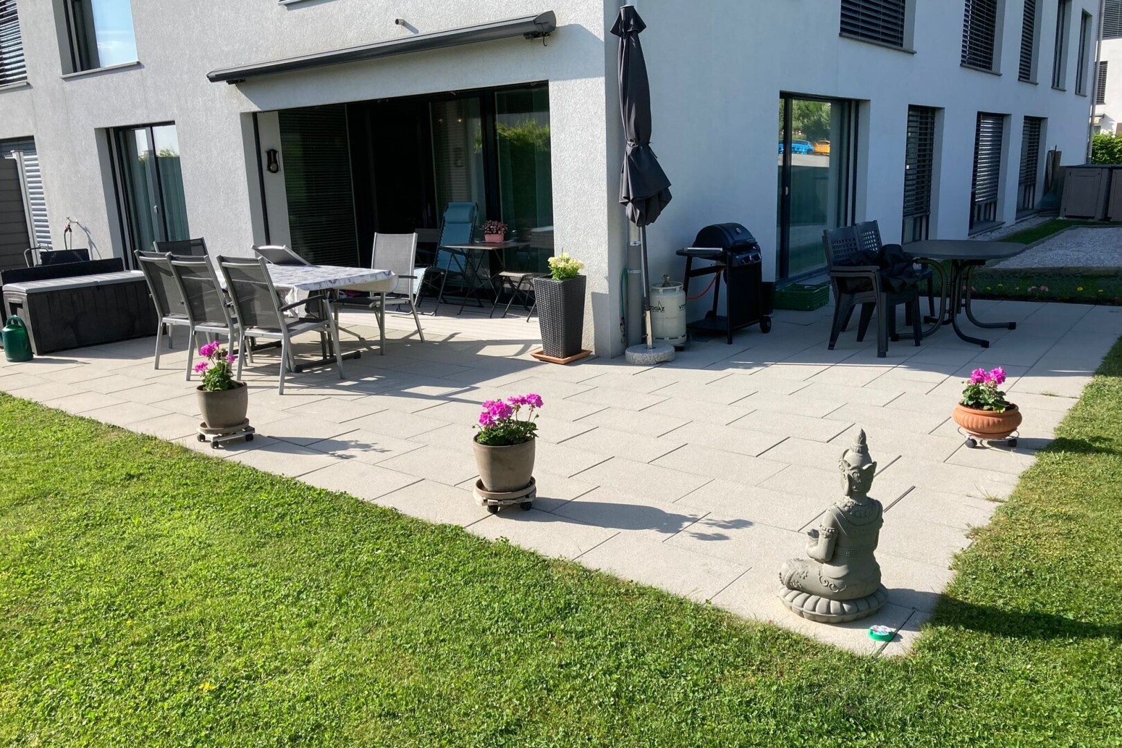 terrasse avec terrasse, property visible, gril, coin repas extérieur, et pelouse